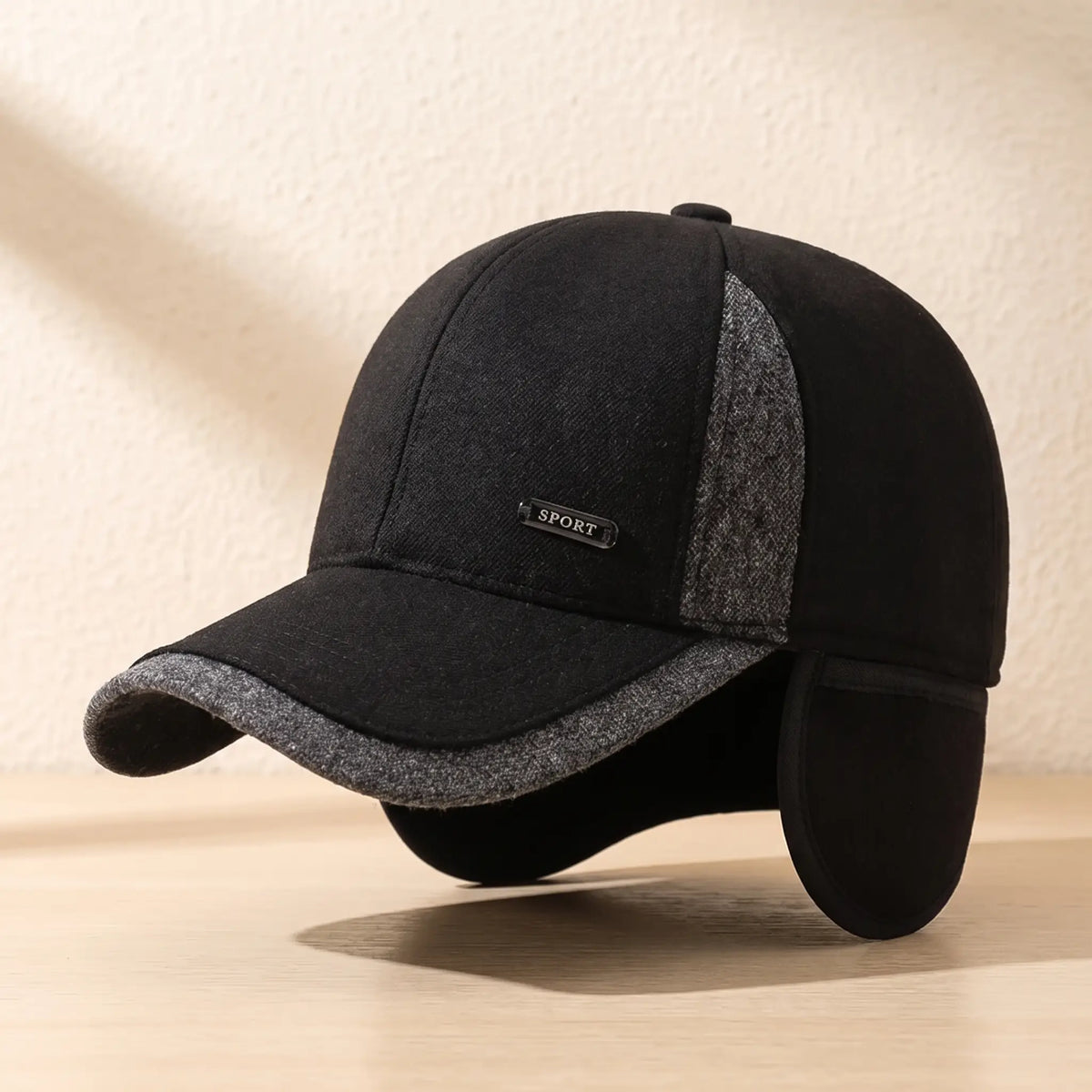 Black winter baseball cap with both ear flaps folded down for extra warmth