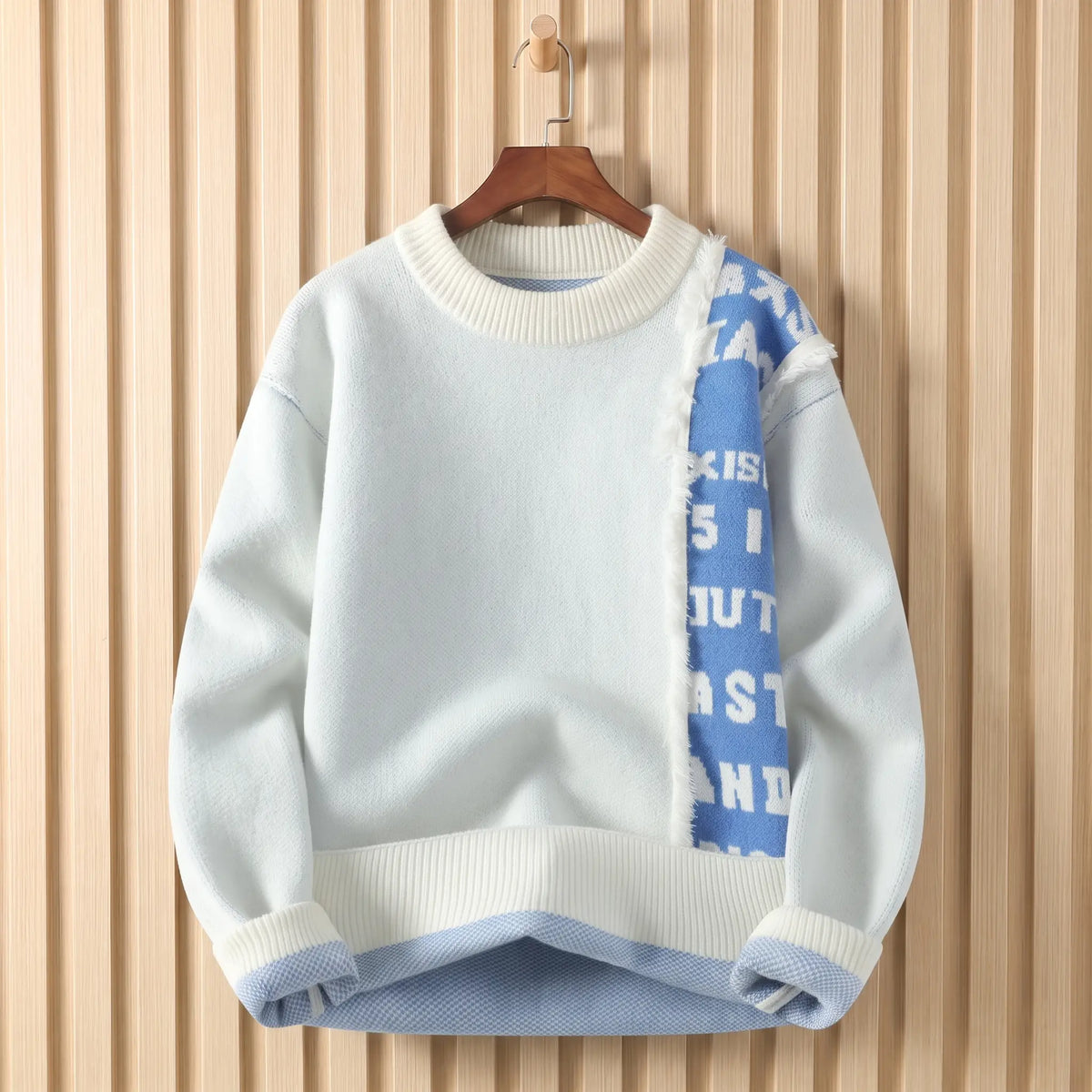 Men's white crew-neck knit sweater with a frayed blue lettered panel down the chest, on a wooden hanger