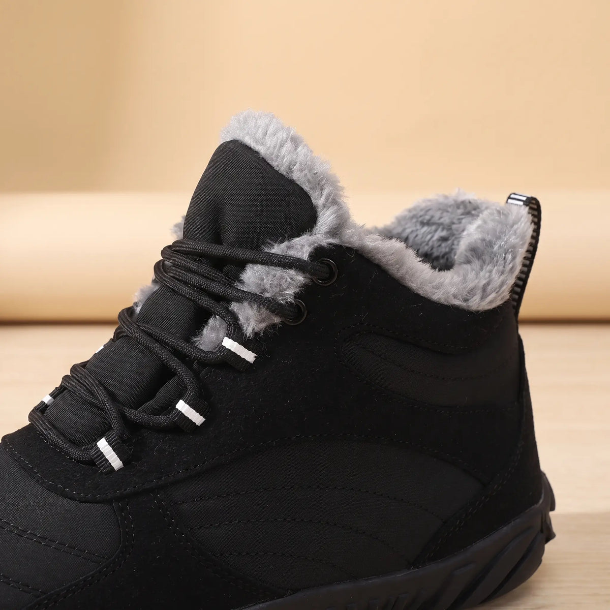 Close-up of the plush collar and laces on the black winter boot