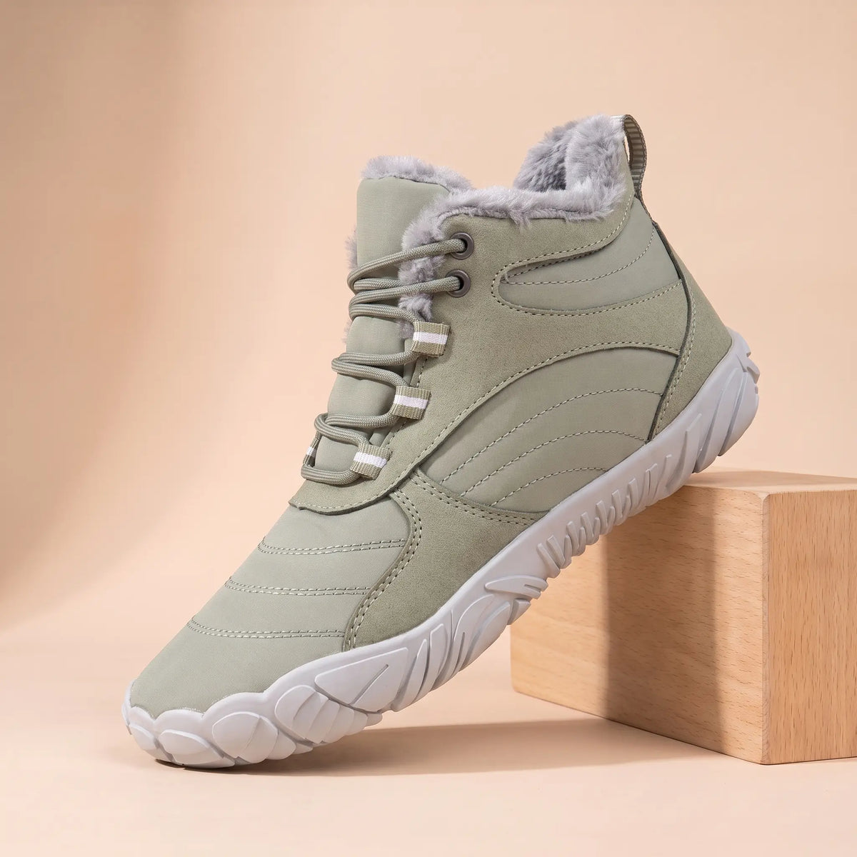 Men's sage green plush-lined wide toe winter boot on an oak block