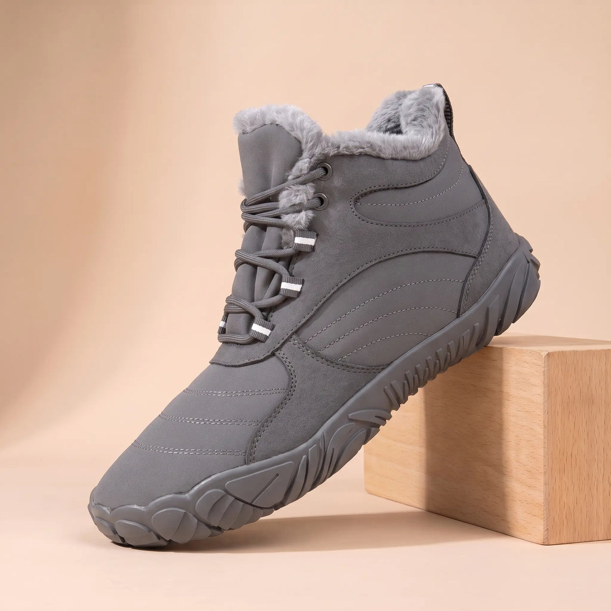 Men's grey plush-lined wide toe winter boot on an oak block