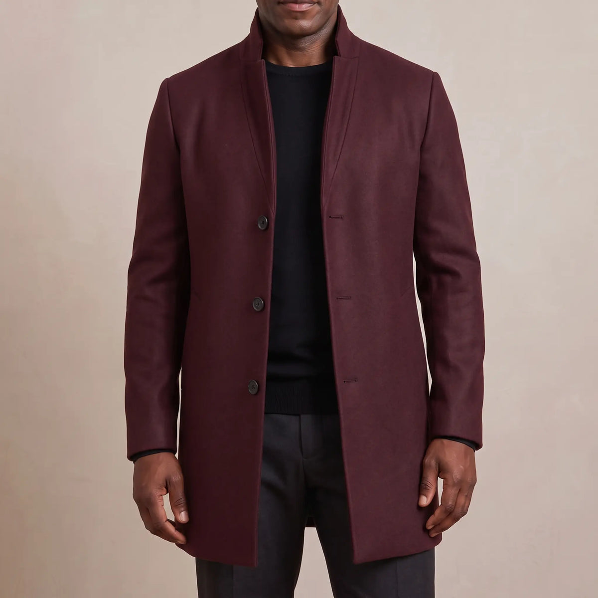 Burgundy funnel neck wool overcoat worn open over a black tee
