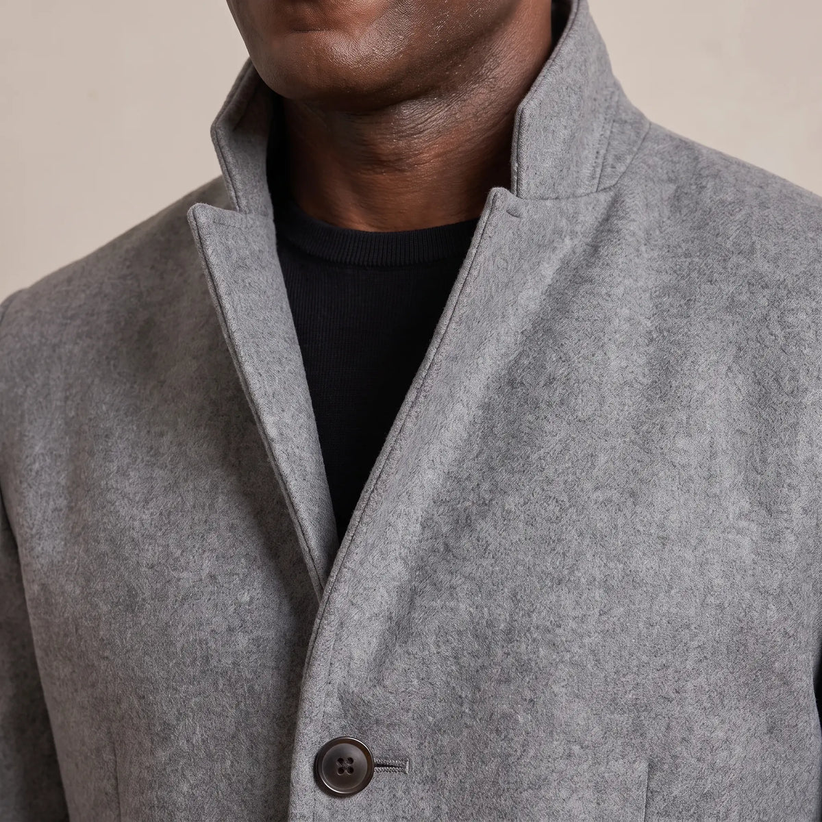 Close up of the tall stand collar and top button on the wool overcoat