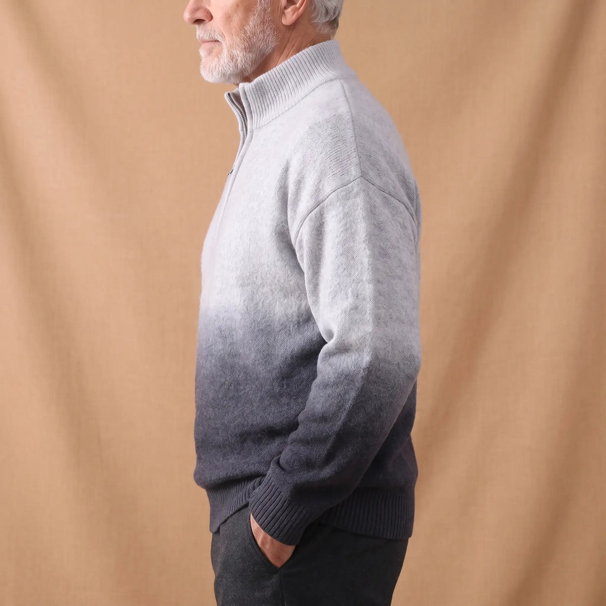 GRADIENT HALF-ZIP SWEATER Grey Side - Side view of a man wearing the grey ombre half-zip sweater with dark trousers