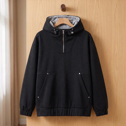 Heather half-zip hoodie in black with grey-lined hood on a wooden hanger