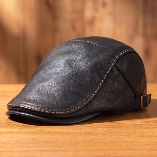 Heritage leather flat cap in black on a wood table
