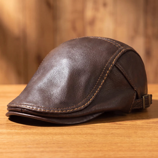 Heritage leather flat cap in brown on a wood table