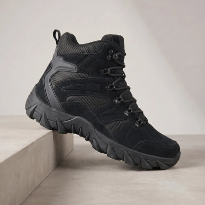 Black high-top tactical boots for men, suede lace-up boot on a concrete plinth