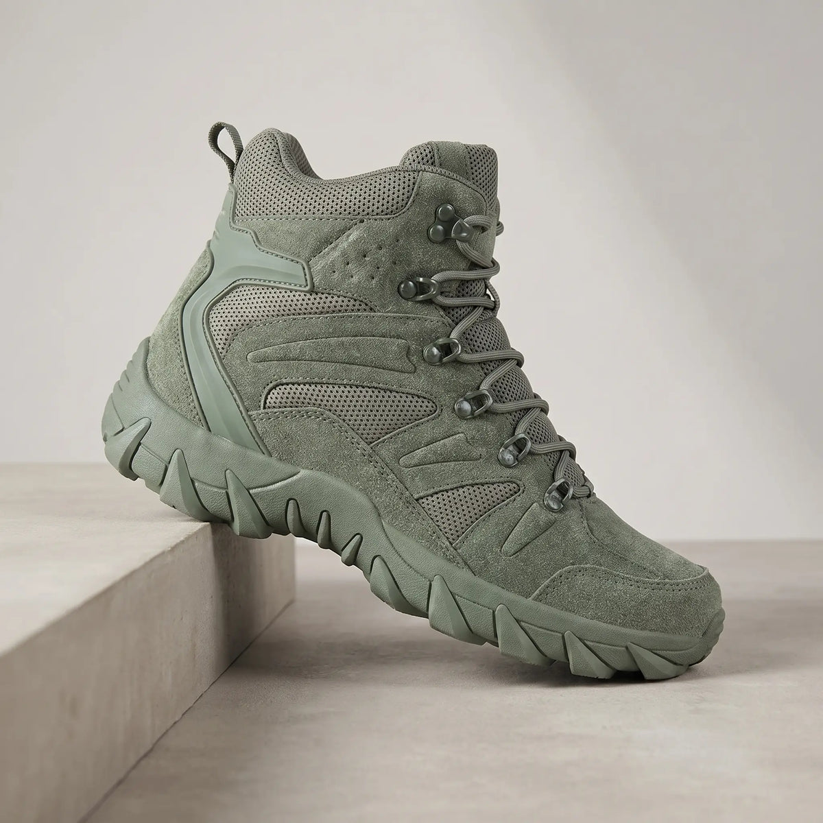Green high-top tactical boots for men, suede lace-up boot on a concrete plinth