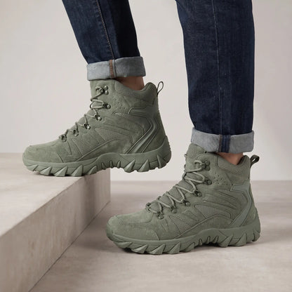 Man wearing green high-top tactical boots with cuffed jeans on a concrete step