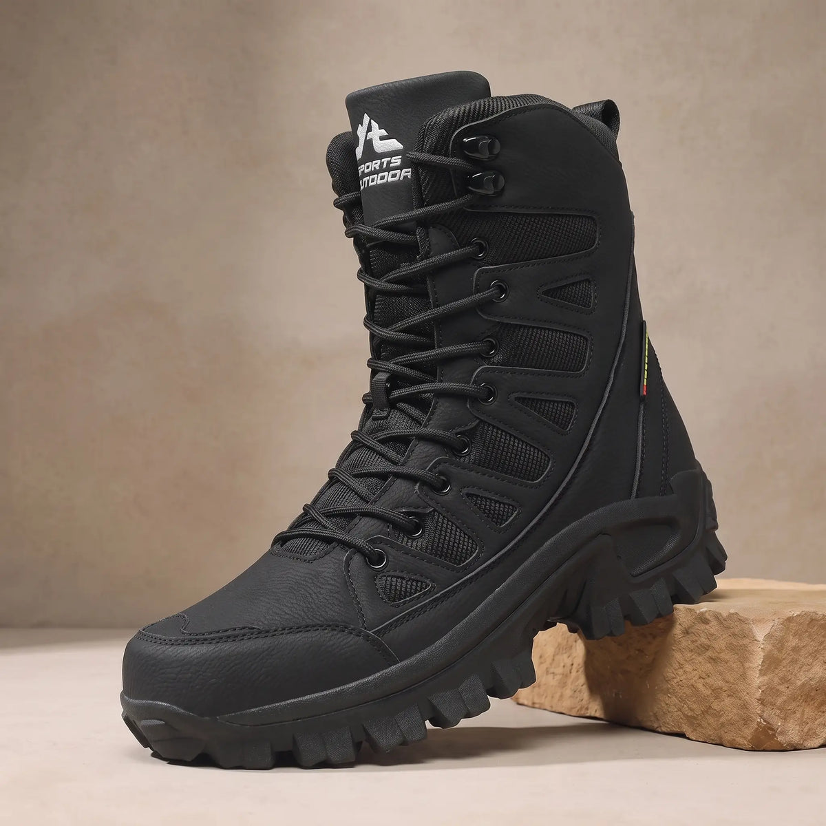 Men's black high lace-up leather boot with vented side panels on a sandstone block