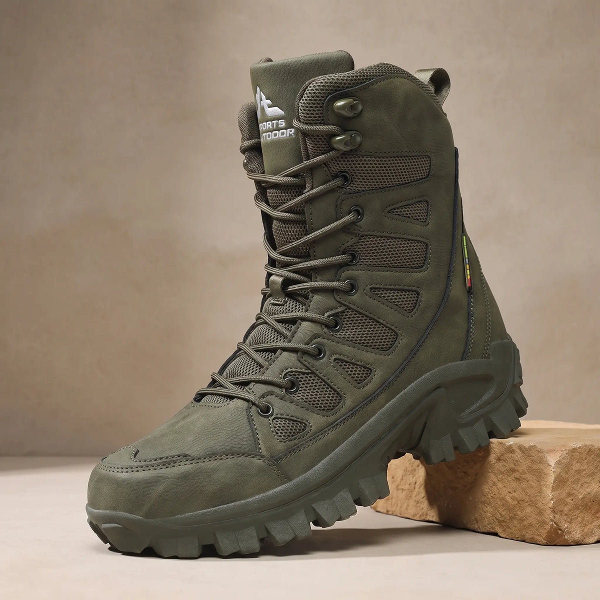 Men's green high lace-up leather boot with vented side panels on a sandstone block