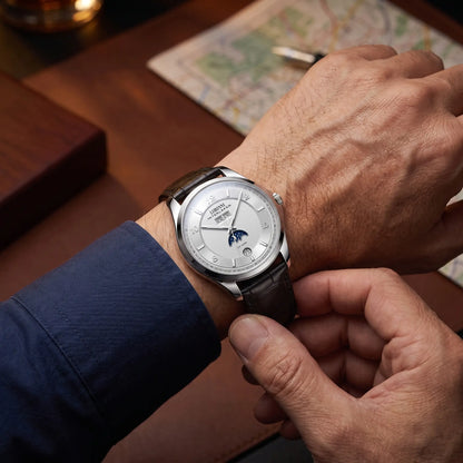 INTERLAKEN MOONPHASE WATCH Silver White worn - man fastening the leather strap of the moon phase watch on his wrist