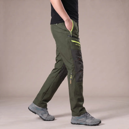 Side view of man walking in green knee panel hiking trousers