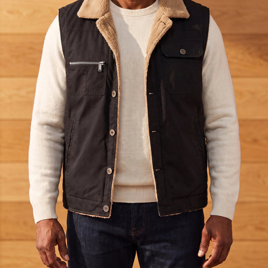 Men's black lapel collar vest with tan sherpa collar and lining, worn open over an off-white sweater