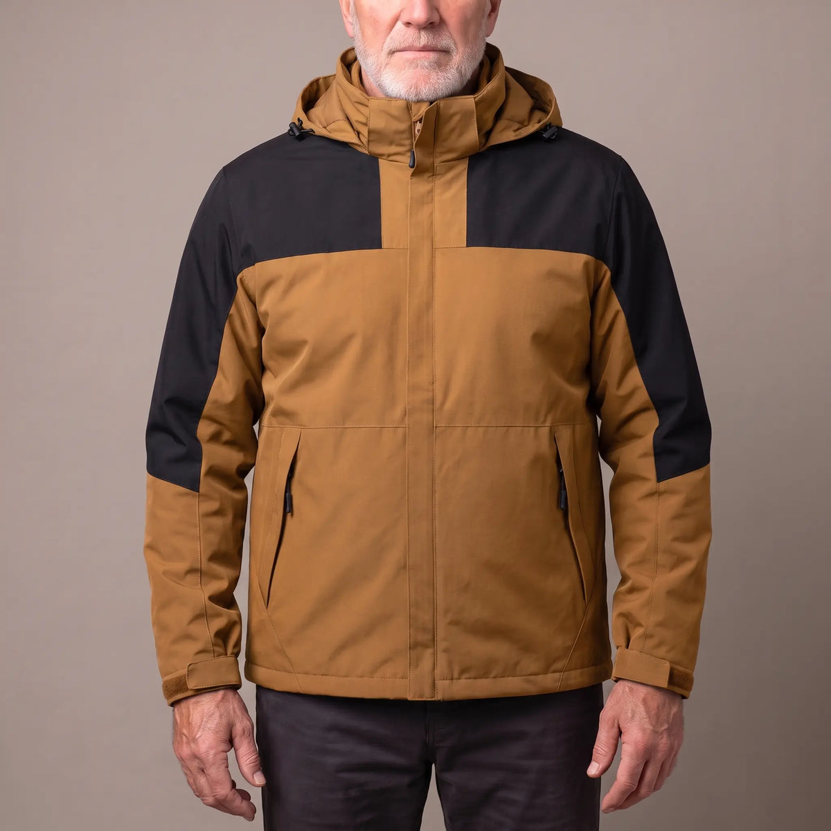 Men's khaki hooded shell jacket with black shoulder panels and a zip-in fleece, worn zipped