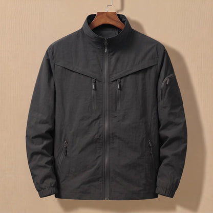 Men's black lightweight utility jacket with five zip pockets on a wooden hanger