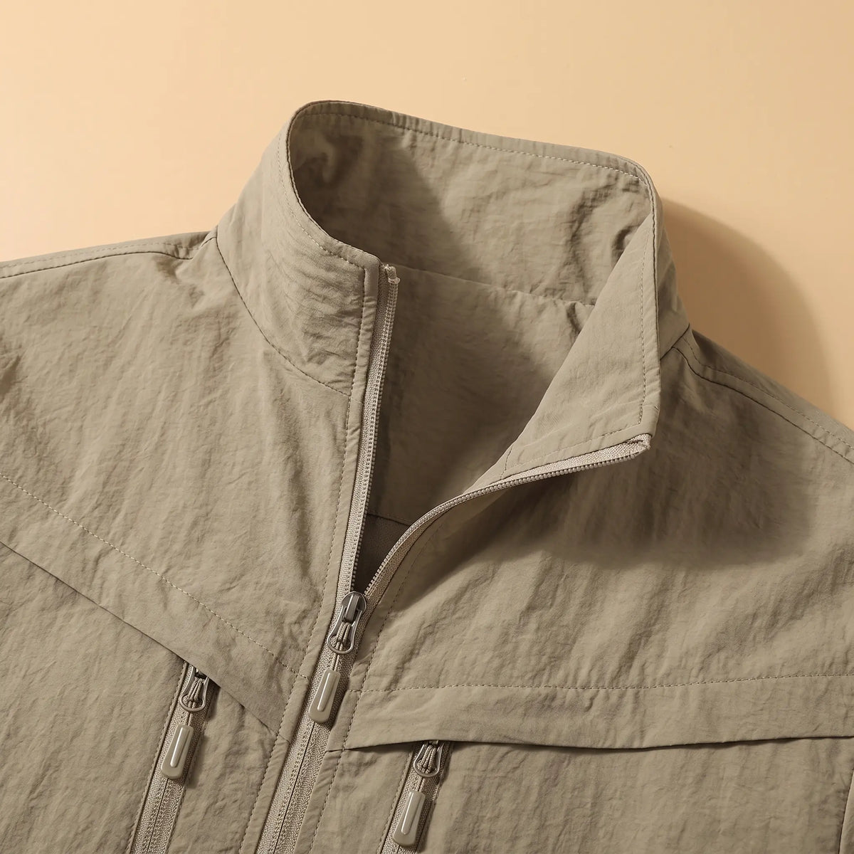 Close-up of the stand collar and zip front on the khaki utility jacket