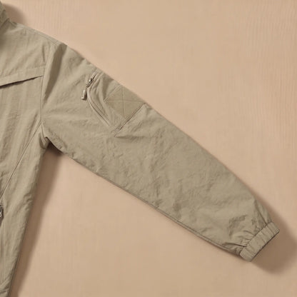 Close-up of the sleeve zip pocket and patch panel on the khaki utility jacket