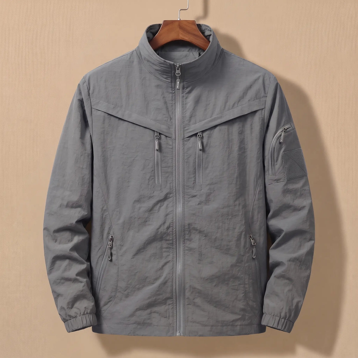Men's grey lightweight utility jacket with five zip pockets on a wooden hanger