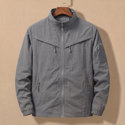 Men's grey lightweight utility jacket with five zip pockets on a wooden hanger