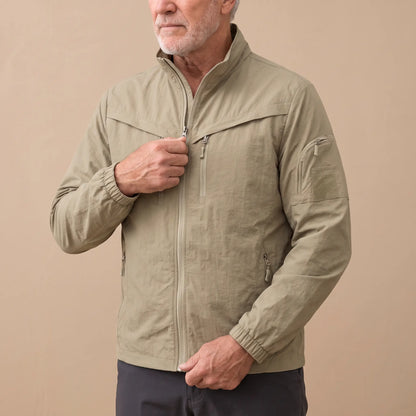 Man wearing the khaki lightweight utility jacket, drawing the zip up