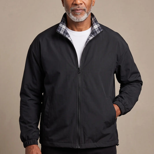 Man wearing the LIGHT REVERSIBLE JACKET in black with a plaid-lined stand collar