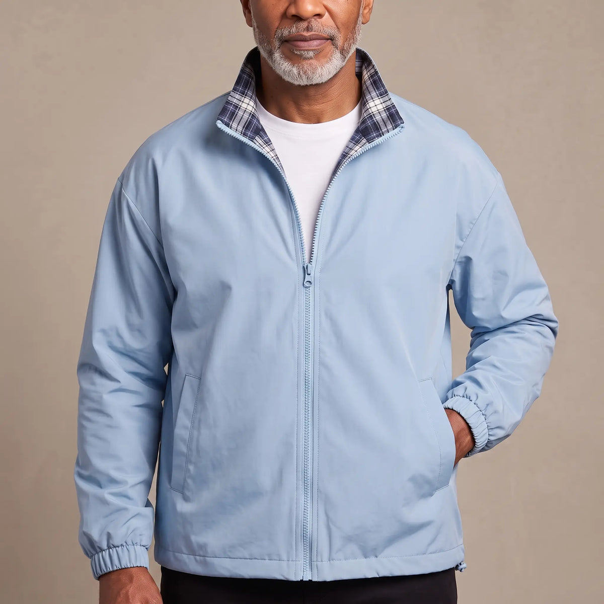 Man wearing the LIGHT REVERSIBLE JACKET in light blue with a plaid-lined stand collar