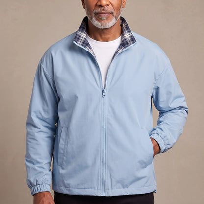 Man wearing the LIGHT REVERSIBLE JACKET in light blue with a plaid-lined stand collar