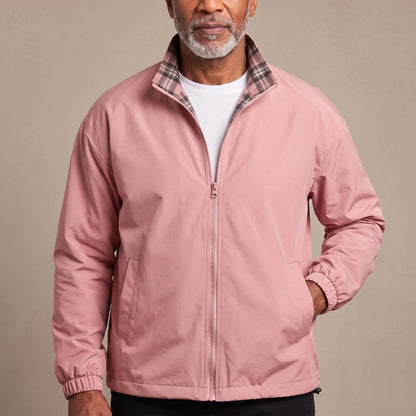 Man wearing the LIGHT REVERSIBLE JACKET in pink with a plaid-lined stand collar