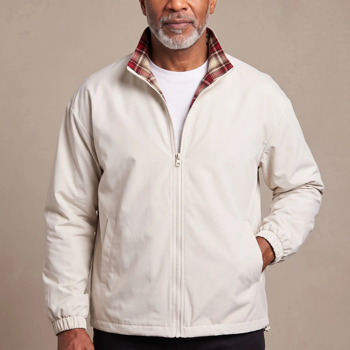 Man wearing the LIGHT REVERSIBLE JACKET in white with a red plaid-lined stand collar