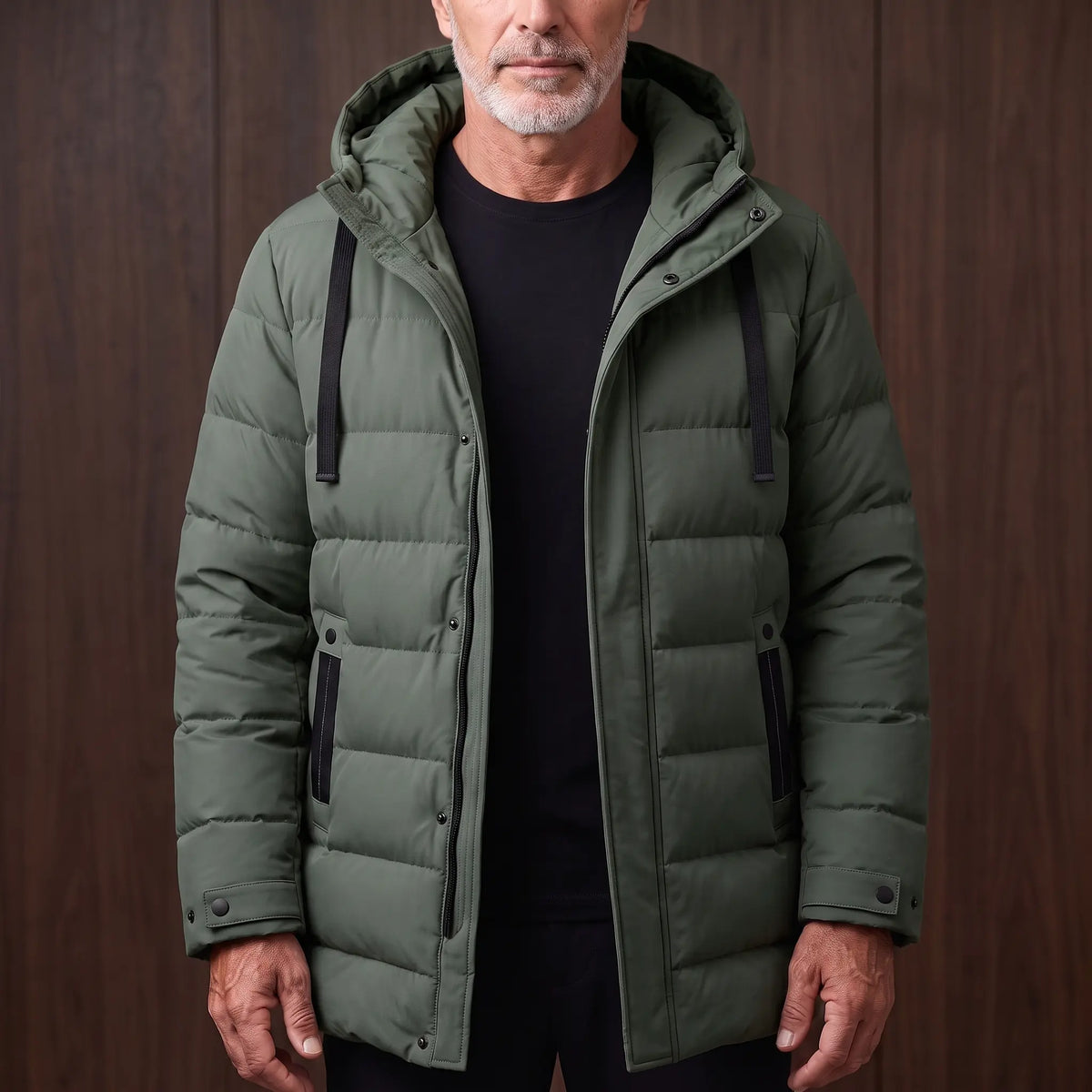 Men's green long hooded puffer coat with quilted padding, worn open over a black tee