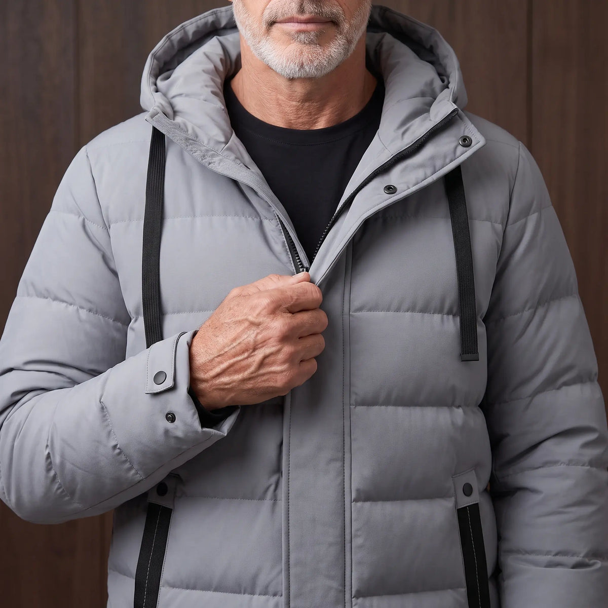 Man zipping up the grey long puffer coat