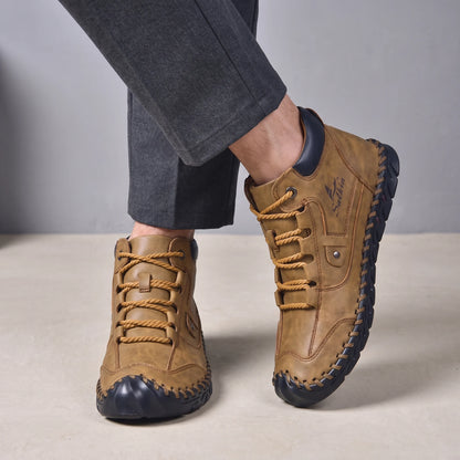 Man wearing the brown lace-up ankle boots with charcoal trousers, low close view of both boots