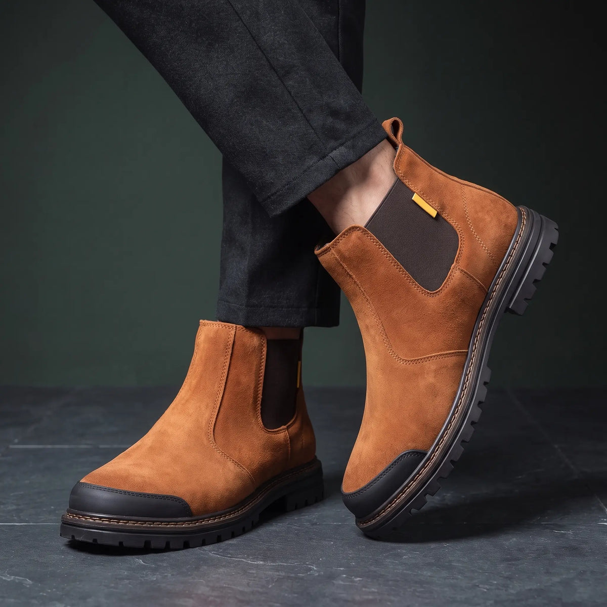 Man wearing both tan work boots with ankles crossed