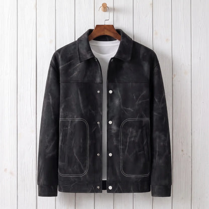 Black marbled dye trucker jacket on a wooden hanger against a whitewashed plank wall