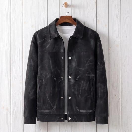 Black marbled dye trucker jacket on a wooden hanger against a whitewashed plank wall