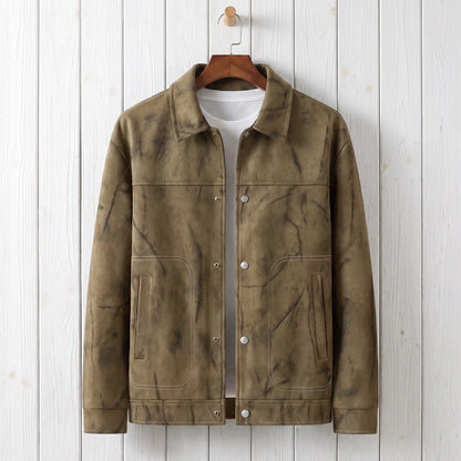 Khaki marbled dye trucker jacket on a wooden hanger against a whitewashed plank wall