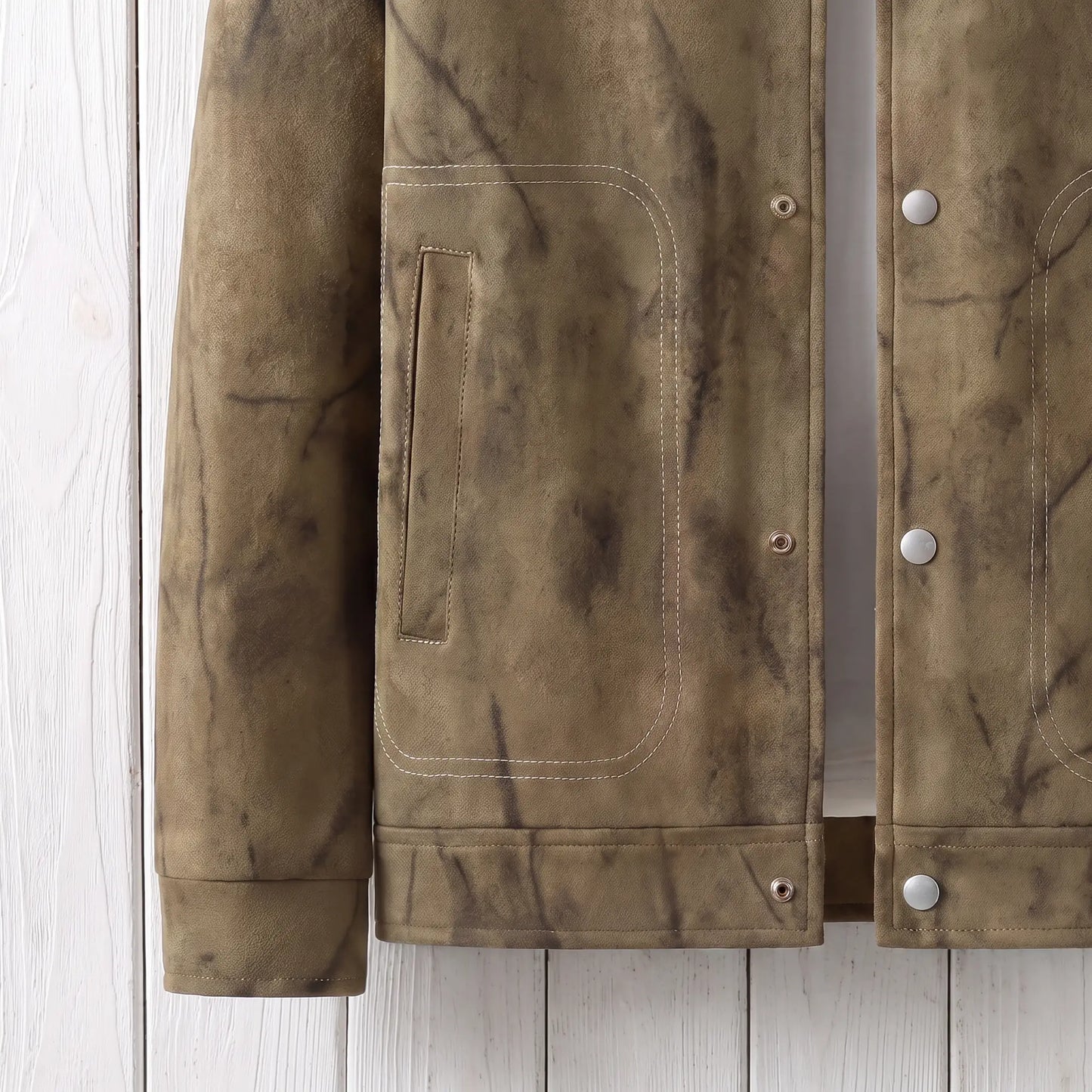 Close up of the waist patch pocket, hem and cuff on the khaki marbled dye jacket