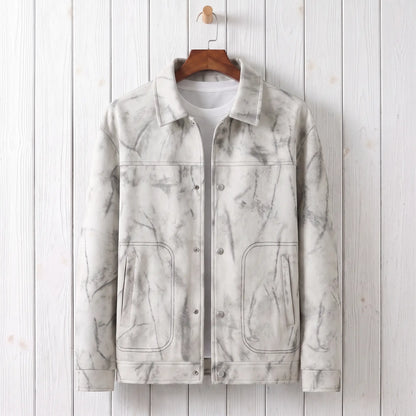 White marbled dye trucker jacket on a wooden hanger against a whitewashed plank wall