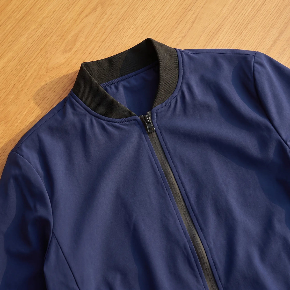 Close detail of MATTE SHELL BOMBER showing the ribbed stand collar and front zip