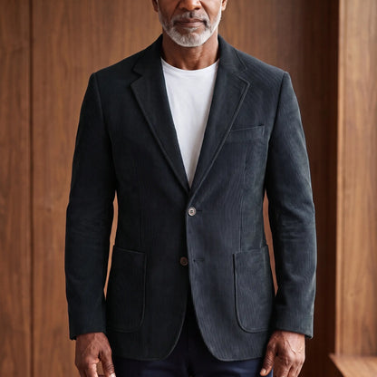 Men's black corduroy blazer with notch lapels and patch pockets, worn over a white T-shirt