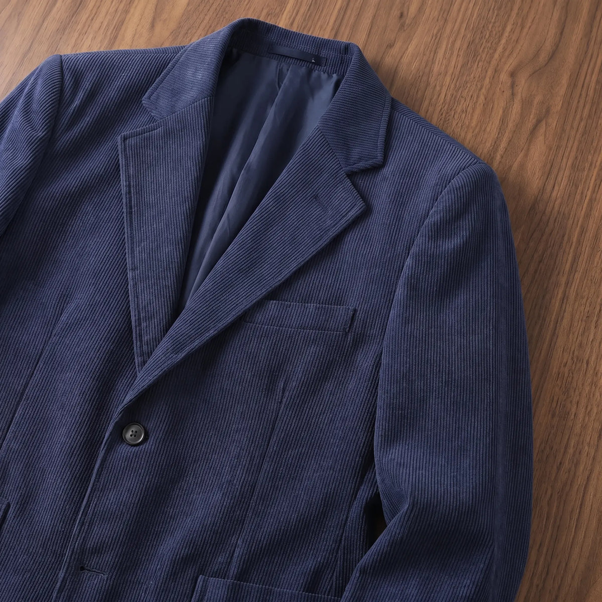 Close up of the notch lapel and chest pocket on the navy blue notch lapel blazer