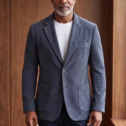 Men's grey corduroy blazer with notch lapels and patch pockets, worn over a white T-shirt