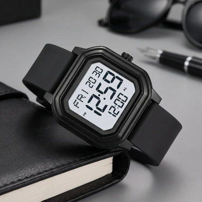 Men's octagon digital watch with black case, light screen and black silicone strap, resting on a black leather folio