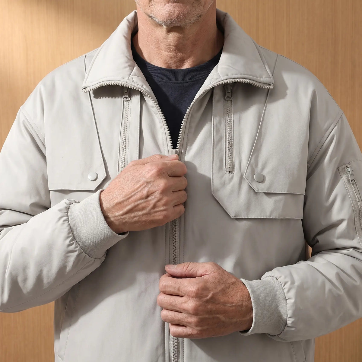 Man zipping up the PADDED COLLAR JACKET in gray