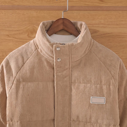 Close up of the stand collar, throat snaps and chest label on the khaki corduroy puffer