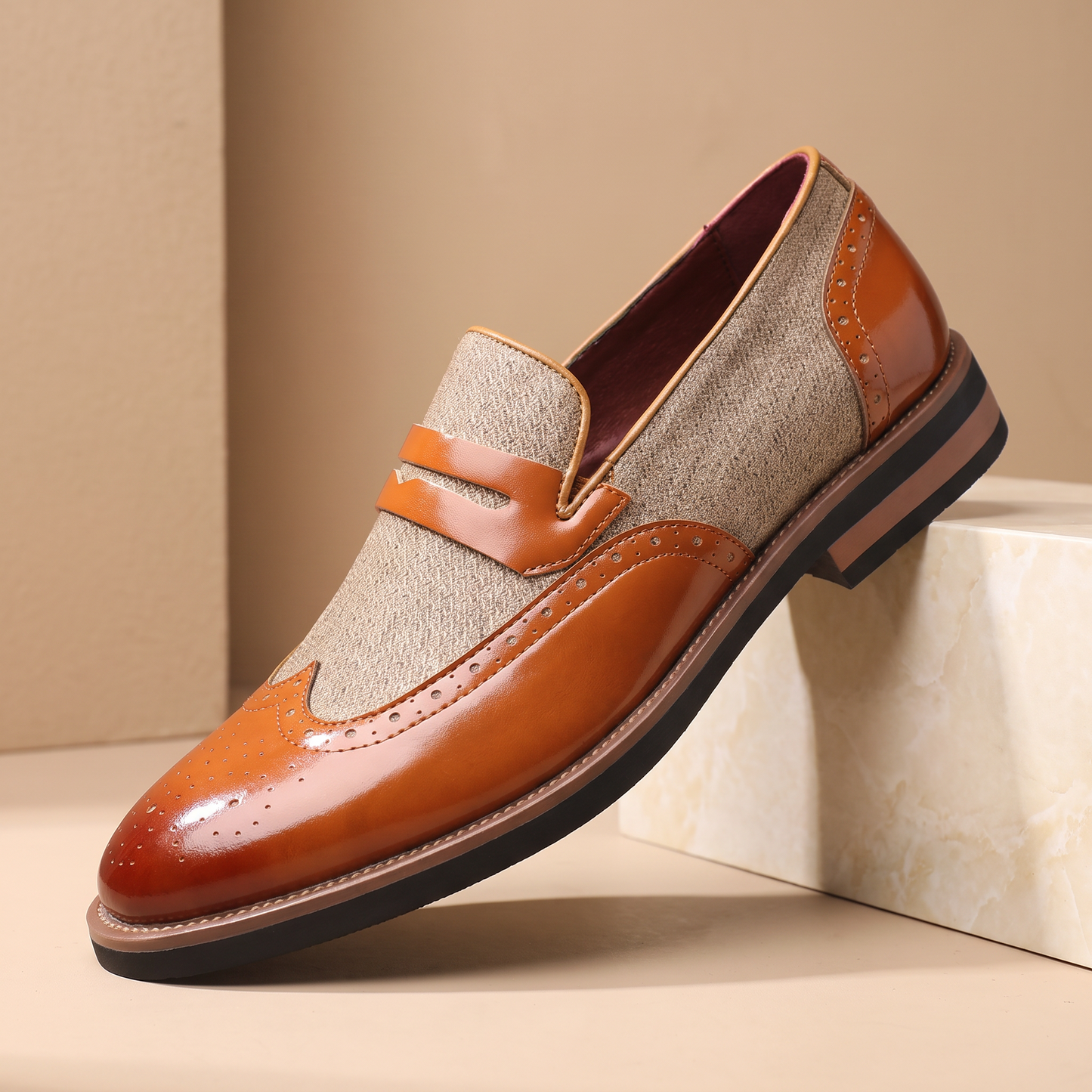 Patent Brogue Loafers in tan - single glossy patent brogue loafer on a cream marble set