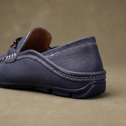 Close up of the padded collar welt stitching and flexible rubber sole on a blue leather driving loafer