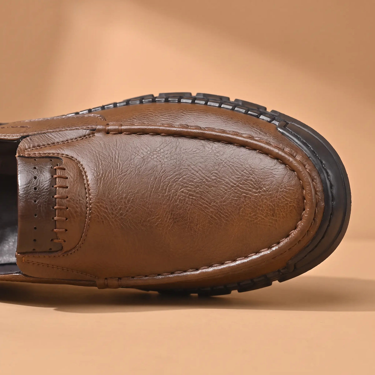 Pebble Moc Loafers in Brown, moc toe and cross-stitched collar band close-up